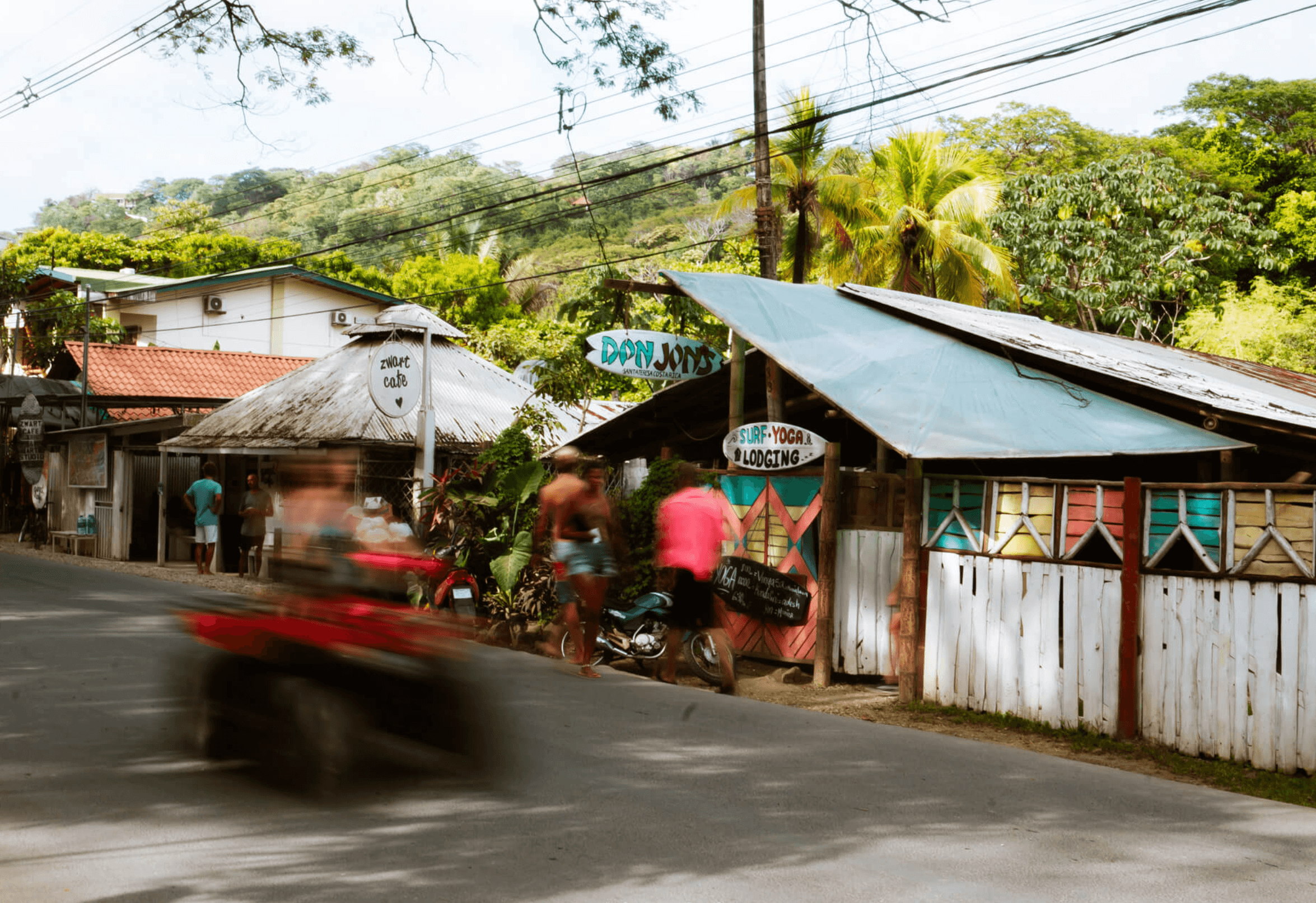 Blurred ATV passing Don Jon's and Zwart Cafe on the main street in Santa Teresa, Costa Rica